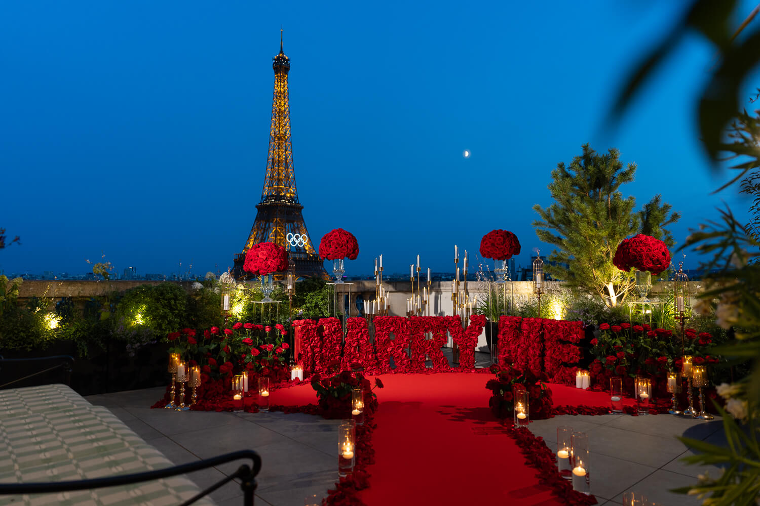 Luxurious "Marry Me" proposal on Shangri-La Paris rooftop. Red carpet, thousands of red roses, and Eiffel Tower view.