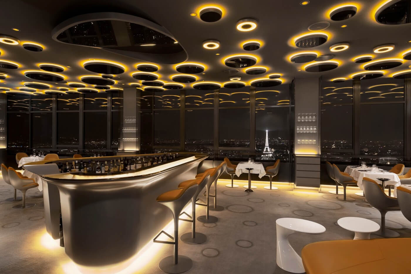 Le Ciel de Paris restaurant interior at night, featuring modern design and Eiffel Tower views from Tour Montparnasse